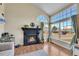 Bright living room with a cozy fireplace, large windows and hardwood floors at 4560 Flanders Way, Denver, CO 80249