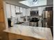 Modern kitchen featuring white cabinets, marble countertops, and stainless steel appliances at 1945 W 102Nd Ave, Thornton, CO 80260