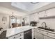 Modern kitchen with white cabinets, marble countertops, and stainless steel appliances at 1945 W 102Nd Ave, Thornton, CO 80260