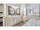Bathroom featuring double vanity sinks, decorative mirrors, and lots of natural light at 7587 Wright Ct, Arvada, CO 80005