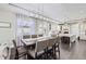 Open concept dining area with an elegant chandelier, hardwood floors, and abundant natural light at 7587 Wright Ct, Arvada, CO 80005