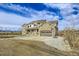 Two-story home with stone facade, attached garage, and basketball hoop at 7587 Wright Ct, Arvada, CO 80005