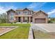 Stunning two-story home featuring a stone facade, a well-manicured lawn, and a spacious three-car garage at 7587 Wright Ct, Arvada, CO 80005