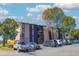 Multi-level apartment building with a parking lot and mature trees on a sunny day at 865 S Quebec St # 302A, Denver, CO 80247