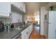 Well-lit kitchen area with stainless steel sink and a view leading to the living room at 865 S Quebec St # 302A, Denver, CO 80247