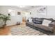 The living room features hardwood floors, a gray sofa, and a view of the stairs at 1970 Willow St, Denver, CO 80220