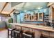 Basement bar area with tile countertop, wooden cabinets, and seating, perfect for entertaining at 7005 S Ash Cir, Centennial, CO 80122