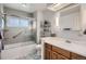 Well-lit bathroom featuring a tub and shower combo with tile surround, vanity, and contemporary fixtures at 7005 S Ash Cir, Centennial, CO 80122