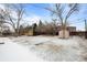 Large backyard with a pink shed, some snow, and many trees at 31 W Fremont Ave, Littleton, CO 80120