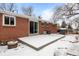 Backyard with a patio covered in snow and a brick house at 31 W Fremont Ave, Littleton, CO 80120