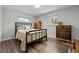 Neutral bedroom with two windows, wood floors, and black metal bed frame at 31 W Fremont Ave, Littleton, CO 80120