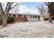 Charming brick home with a covered porch and snow-dusted front yard at 31 W Fremont Ave, Littleton, CO 80120