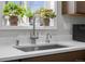 Stainless steel kitchen sink sits in front of a window adorned with vibrant potted plants at 31 W Fremont Ave, Littleton, CO 80120