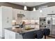 Modern kitchen boasts stainless steel appliances, a granite island with seating, and sleek white cabinetry at 65 Newport St, Denver, CO 80230
