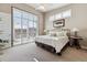 Bright bedroom boasts a comfortable bed, large windows with plantation shutters, and neutral tones at 65 Newport St, Denver, CO 80230