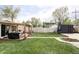 Expansive backyard with a well-maintained lawn, wooden fence, storage shed, and patio, ideal for outdoor activities at 873 S Raritan St, Denver, CO 80223