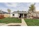 Spacious backyard features lush grass, a covered patio, a seating area, and a wooden fence at 873 S Raritan St, Denver, CO 80223