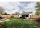 Wide backyard view features lush grass, a covered patio, a seating area, and a wooden fence at 873 S Raritan St, Denver, CO 80223