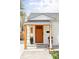 Inviting entryway features a striking orange door and manicured landscaping at 873 S Raritan St, Denver, CO 80223