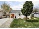 Charming home featuring a manicured lawn, vibrant orange door, and inviting curb appeal at 873 S Raritan St, Denver, CO 80223