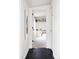 Hallway view into a bedroom featuring crisp white walls, and a modern black tile floor at 873 S Raritan St, Denver, CO 80223