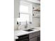 Bright kitchen features stainless steel sink, stylish shelves, and stone countertops at 873 S Raritan St, Denver, CO 80223