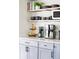 Close up of a coffee station featuring a coffee maker, fruit, and open shelving at 873 S Raritan St, Denver, CO 80223