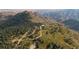 Breathtaking aerial view of a property nestled in a lush, mountainous landscape with mature trees at 12421 High Country Trl, Littleton, CO 80127
