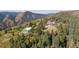 Expansive mountain property featuring a modern home and large storage shed surrounded by lush greenery at 12421 High Country Trl, Littleton, CO 80127