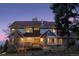 Two-story home with stone accents and a large deck at dusk at 12421 High Country Trl, Littleton, CO 80127