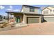 Two-story home with a covered porch and attached garage, showcasing attractive landscaping at 19059 E 54Th Pl, Denver, CO 80249