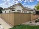 Beautiful house features a wooden fence, with rock landscaping and grass, perfect for privacy at 71 Woodland Cir, Highlands Ranch, CO 80126