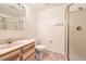 Bright bathroom featuring a glass door shower, marble vanity, and neutral color scheme at 71 Woodland Cir, Highlands Ranch, CO 80126