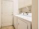 Functional laundry room with appliances, white cabinets, and easy access to the door at 71 Woodland Cir, Highlands Ranch, CO 80126