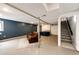 Basement area with painted floor, drywall ceiling, structural poles, and stairs to upper level at 7840 W Portland Ave, Littleton, CO 80128