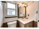 Bathroom features a neutral color scheme, modern vanity, and framed mirror at 7840 W Portland Ave, Littleton, CO 80128