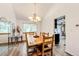 Well-lit dining room with a large wood table, views of the kitchen, and a decorative mirror at 7840 W Portland Ave, Littleton, CO 80128