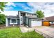 Charming two-story home with a well-manicured lawn, large driveway, and a gray and white facade at 7840 W Portland Ave, Littleton, CO 80128