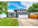 Charming two-story home with a well-manicured lawn, large driveway, and a gray and white facade at 7840 W Portland Ave, Littleton, CO 80128