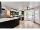Spacious kitchen featuring modern black cabinets, stainless steel appliances, and a bright dining nook at 7840 W Portland Ave, Littleton, CO 80128