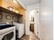 Convenient laundry room with washer, dryer, and storage shelves at 7840 W Portland Ave, Littleton, CO 80128