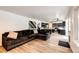 Open concept living room with hardwood flooring and modern black kitchen at 7840 W Portland Ave, Littleton, CO 80128