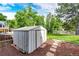Backyard shed with a metal roof and a brick walkway in a grassy yard at 7840 W Portland Ave, Littleton, CO 80128