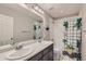 Bathroom with double sinks, shower/tub combo, and patterned shower curtain at 15983 E Warner Dr, Denver, CO 80239