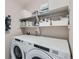 Laundry room with Whirlpool washer and dryer and ample storage at 15983 E Warner Dr, Denver, CO 80239