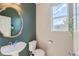 Small powder room with pedestal sink and a decorative mirror at 15983 E Warner Dr, Denver, CO 80239