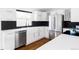 Modern kitchen featuring white cabinets, stainless steel appliances, dark backsplash, and plenty of natural light from the window at 5945 Dudley Ct, Arvada, CO 80004