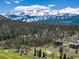Scenic aerial view of the property with a lush green golf course and snow-capped mountains in the background at 2250 Highlands Dr, Breckenridge, CO 80424