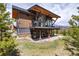 Picturesque back exterior featuring mountain views, deck, and manicured lawn at 2250 Highlands Dr, Breckenridge, CO 80424