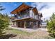 Expansive back exterior featuring deck, hot tub, and manicured lawn at 2250 Highlands Dr, Breckenridge, CO 80424